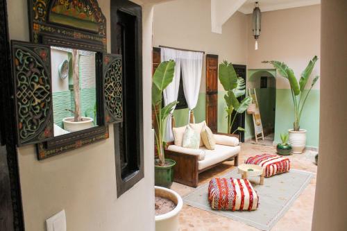 a living room filled with lots of potted plants at Riad Amra in Marrakesh