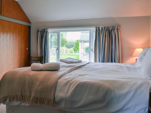 una camera da letto con un grande letto con due asciugamani di Half House a Nethy Bridge
