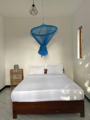 ein Schlafzimmer mit einem großen Bett mit blauer Decke in der Unterkunft The Pearl in Marawila
