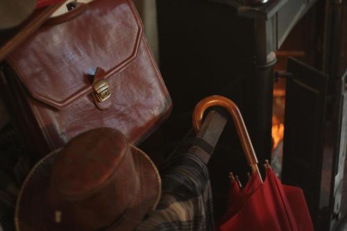 a person with a hat standing next to a brown purse at Chateaux Constantin Agistro in Ángistron