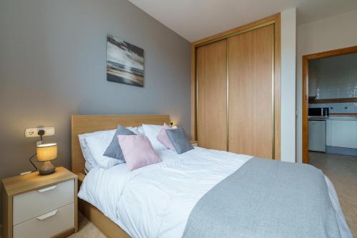 a bedroom with a bed with pink and blue pillows at CT 138 - La Cala Boulevard - Apartement I in La Cala de Mijas