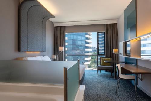 マプトにあるラディソン ブル ホテル＆レジデンス マプトのベッドとデスクが備わるホテルルームです。