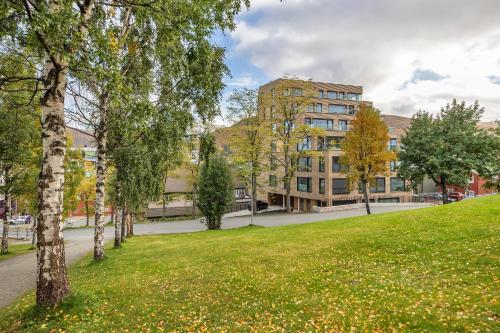 a park with trees and a building in the background at Penthouse in Downtown Tromsø NEW in Tromsø