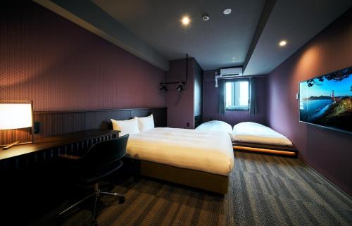 a hotel room with a bed and a flat screen tv at Rakuten STAY Kokura Station Standard Double Room in Kitakyushu