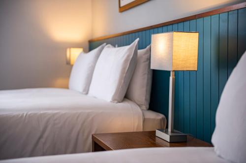 a hotel room with two beds and a table with a lamp at Highfield Hotel By Greene King Inn in Middlesbrough