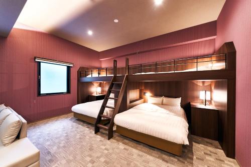 2 letti a castello in una camera con pareti rosse di Rakuten STAY Kokura Station Family Room a Kitakyushu
