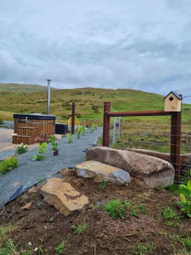 a garden with a fence and a bird house at Slieve Croob Glamping in Ballyward