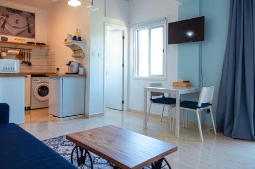 Calypso في بافوس: غرفة معيشة مع طاولة ومطبخ