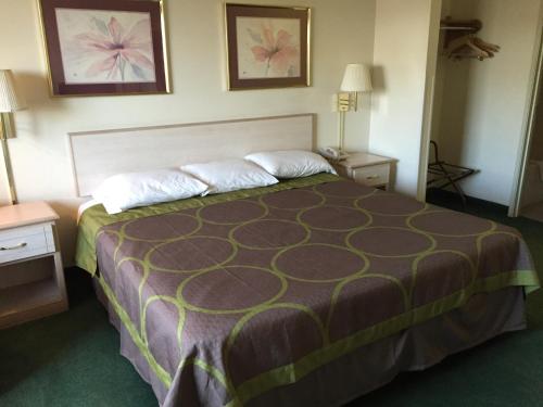 a hotel room with a large bed and two night stands at Super 8 by Wyndham Willcox in Willcox
