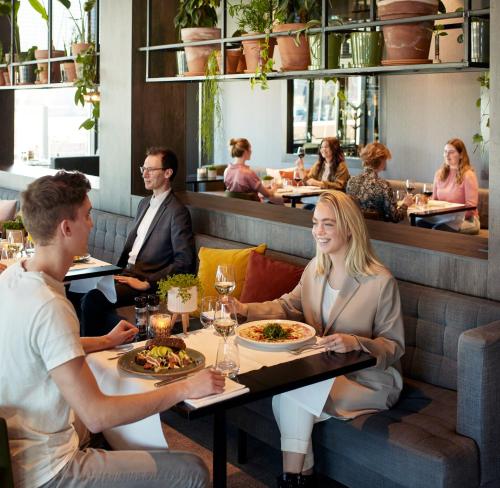 a group of people sitting in a restaurant at Van der Valk Hotel Nijmegen-Lent in Nijmegen