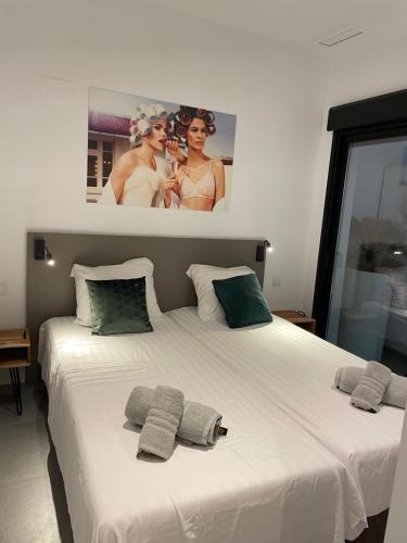 a bedroom with a large white bed with three pillows at Casa 34 in Guardamar del Segura