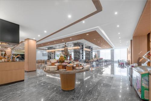a restaurant with a counter with food on it at Holiday Inn Foshan Nanhai Central by IHG in Foshan