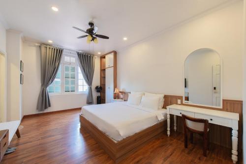 a bedroom with a bed and a desk and a mirror at Le Soleil Boutique Hotel in Da Lat
