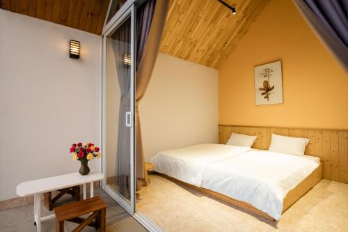sypialnia z łóżkiem i szklaną ścianą w obiekcie LaVa Haus Homestay Hòa Bình - Venuestay w mieście Hòa Bình