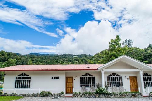 a white house with a mountain in the background at Downtown Suites in Boquete