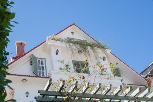 a white house with a white picket fence at Le Soleil Boutique Hotel in Da Lat
