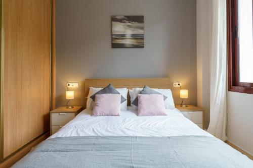 1 dormitorio con 1 cama con 2 almohadas rosas en CT 143 - La Cala Boulevard - Apartement II en La Cala de Mijas