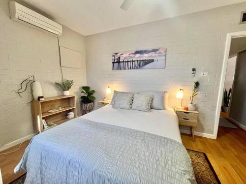 1 dormitorio con 1 cama blanca grande en una habitación en Tastefully renovated - 3 bedroom apartment, en South Hedland