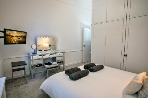 a bedroom with a bed with a desk and a mirror at Finest Retreats - Chelsea Luxury Apartment in London