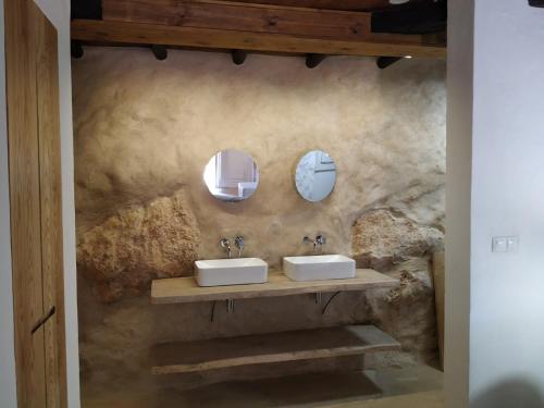 uma casa de banho com dois lavatórios e dois espelhos em Casa Cueva El Naranjo Rocabella em El Chorro