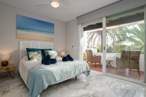 sypialnia z łóżkiem i przesuwanymi szklanymi drzwiami w obiekcie Townhouse beachfront in Costalita w mieście Estepona