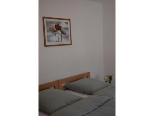 a bedroom with two beds and a picture on the wall at Ferienwohnung am Hof in Zwiefalten