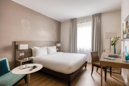 a hotel room with a large bed and a desk at Citadines Toison d’Or Brussels Aparthotel in Brussels