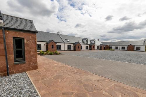 a row of houses with a driveway in front at Westertonhill Lodge 5 Newbuild with Hot Tub Option in Balloch