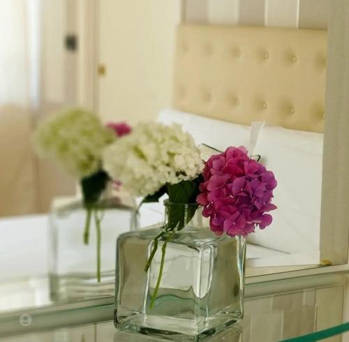 two vases with flowers in them on a table at Hotel Sant'Andrea in Santa Margherita Ligure