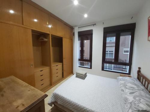 a bedroom with a bed and a dresser and two windows at Apartamento Ideal Retiro - Centro de Madrid in Madrid