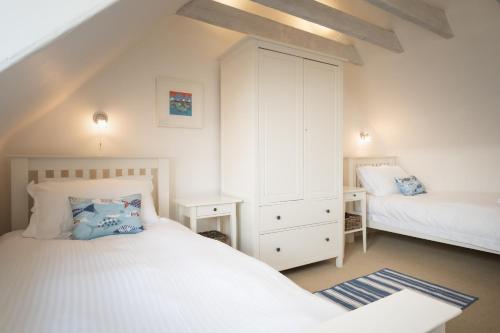 a bedroom with two beds and a dresser at Seaside cottage on Moray coast in Portknockie