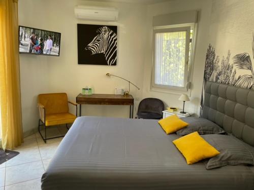 sypialnia z dużym łóżkiem z żółtymi poduszkami w obiekcie STUDIO BEAUREGARD - TERRASSE et JARDIN w Nancy