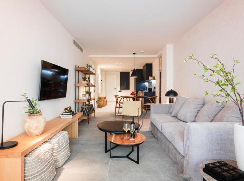 a living room with a couch and a table at TocToc Suites Olof Palme - Viviendas Vacacionales in Las Palmas de Gran Canaria