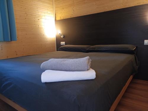 Una cama con dos toallas encima. en CAMPING DE BESALU en Besalú