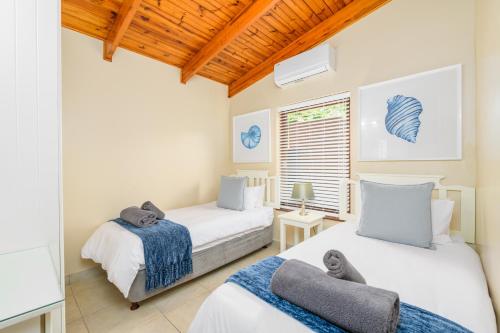 1 dormitorio con 2 camas y ventana en San Lameer Villa 3409 - 3 Bedroom Classic - 6 pax - San Lameer Rental Agency en Southbroom