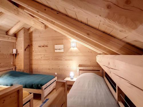 eine Blockhütte mit 2 Betten in einem Zimmer in der Unterkunft Appartement luxueux aux pieds des pistes avec parking couvert - FR-1-416-184 in La Toussuire