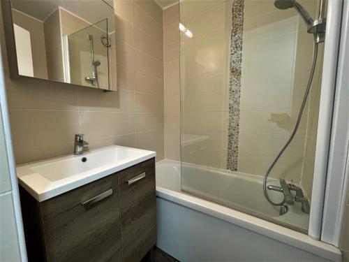 une salle de bain avec un lavabo, une douche et une baignoire dans l'établissement Appartement Chaleureux 4 Pers - Pied des Pistes - Quartier Brelin - FR-1-452-270, aux Menuires