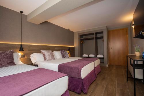 a hotel room with two beds with purple sheets at Yomo Eureka in Andorra la Vella