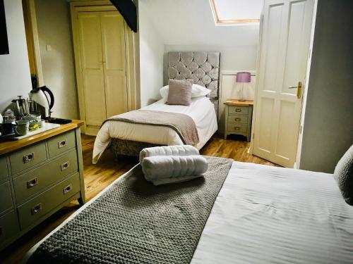 a bedroom with two beds and a sink and a mirror at Cartref Guest House in Carlisle
