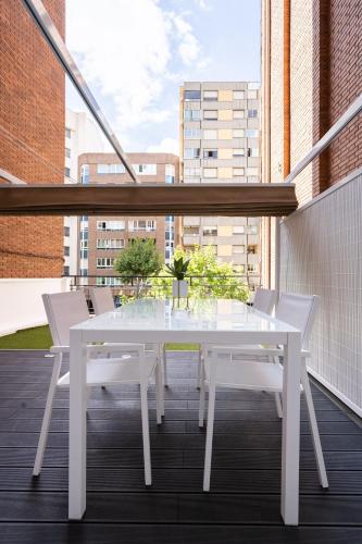 a white table and chairs on a balcony at Apartamento Mani en Avenida España con terraza in Albacete