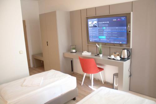 Habitación con cama y escritorio con monitor en Isar City Hotel en Múnich