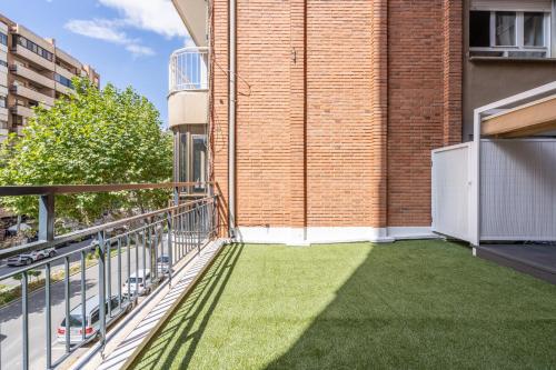 a balcony with grass on the side of a building at Apartamento Mani en Avenida España con terraza in Albacete