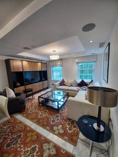 a living room with a couch and a table at Buckingham Palace Residences by Aeria Apartments in London