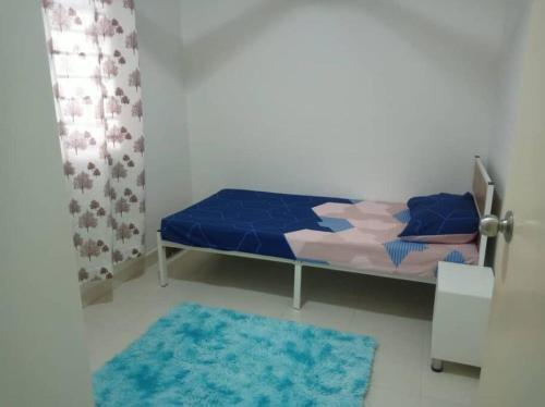 a bedroom with a bed and a blue rug at Debayu Homestay with Free Parking at Setia Alam in Shah Alam