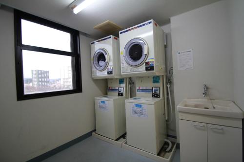a laundry room with washing machines and a sink at APA Hotel Kagoshima Kokubu in Kirishima