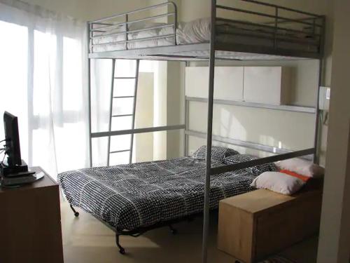 a bedroom with two bunk beds and a television at Precioso apartamento a pie de pista en Sierra Nevada in Sierra Nevada