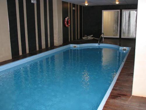 una gran piscina azul en un edificio en Precioso apartamento a pie de pista en Sierra Nevada, en Sierra Nevada