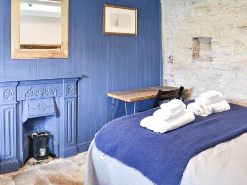 a blue room with a bed with towels on it at Writers Cottage - Uk33475 in Nenthead