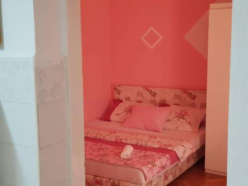 a room with a bed with pink walls at Montenegro Apartmant's in Kotor