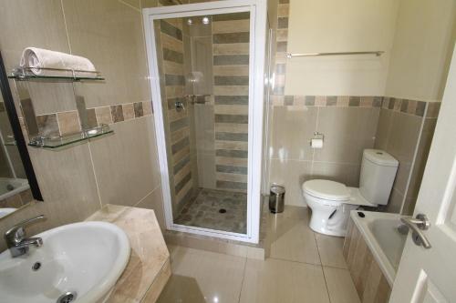 a bathroom with a shower and a sink and a toilet at Saints View Resort Unit 1 in Uvongo Beach